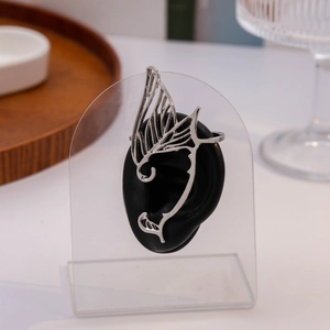 Close-up of silver butterfly wing ear cuff showing intricate hollow fairy design