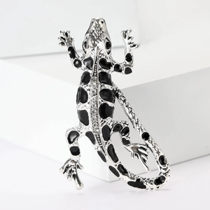 Detailed view of silver lizard brooch featuring black enamel and sparkling rhinestones
