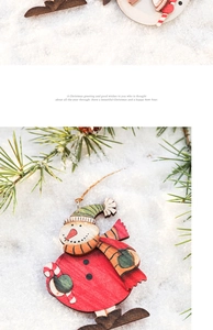 Detail view of colorful wooden snowman ornaments on snow background with pine needles