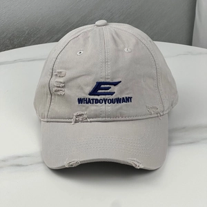 Detailed view of embroidery and distressed holes on this vintage grey cotton baseball cap