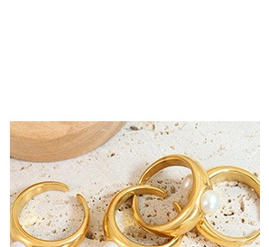 Detail van verstelbare 18K vergulde titanium ringen met elegante witte schelpparels