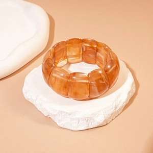 Close-up of amber marble texture acrylic geometric stretch bracelet on a white stone