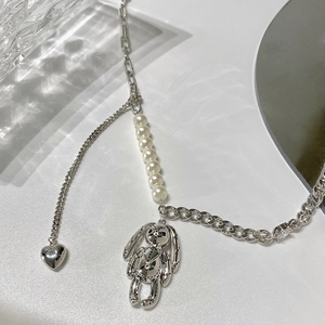 Détail du collier géométrique argenté avec pendentif lapin, perles et un petit cœur