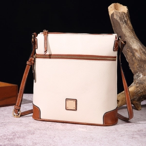 Detailed view of cream and brown pebbled leather texture on vintage crossbody handbag