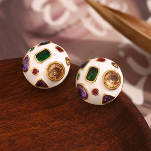 Macro detail of 18K gold-plated dome earrings with white enamel and colorful crystals