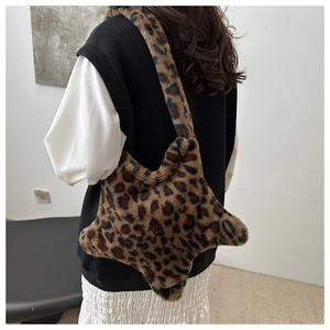 Détail d'un sac cabas en peluche léopard en forme d'étoile porté par un mannequin en automne