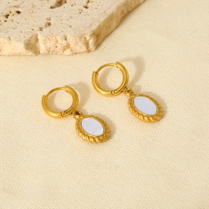 Macro detail of 18K gold-plated oval resin earrings with twisted rope border texture