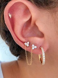 Macro view of gold flower earrings set featuring zircon studs and S925 engraved silver chain