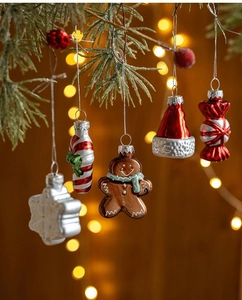 Close-up of festive Christmas ornaments hanging on pine branches with warm bokeh lighting