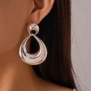 Dettaglio degli orecchini a goccia in argento oversize con design cavo metallico