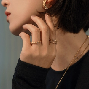 Brushed gold S925 silver rings and earrings set with tiny diamonds on a model
