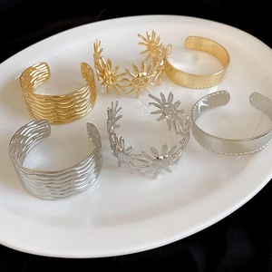 Detailansicht von strukturierten offenen Armreifen aus Metall in Gold und Silber