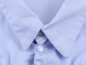 Close-up of light blue shirt featuring classic lapel collar and white front buttons
