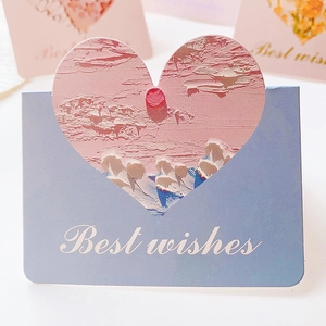 Close-up of a blue greeting card with heart cutout and Best Wishes script lettering
