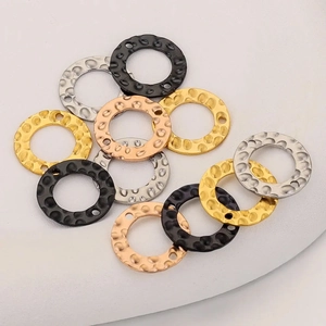 Macro shot of hammered metal discs in gold, silver, black, and rose gold for DIY jewelry