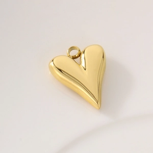Close-up of golden stainless steel heart charm with polished finish and circular ring