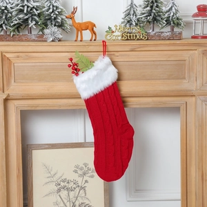 Détail d'une chaussette de Noël tricotée rouge avec revers en fausse fourrure blanche