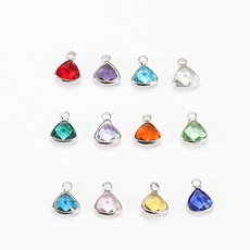 Macro shot of twelve colorful teardrop birthstone pendants with silver metal frames
