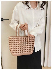 Detail of light pink woven hollow jelly tote bag with handles for summer beach vacations