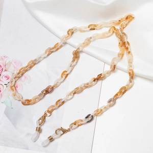 Detail of amber tortoiseshell acrylic eyewear chain with gold lobster clasp and loops