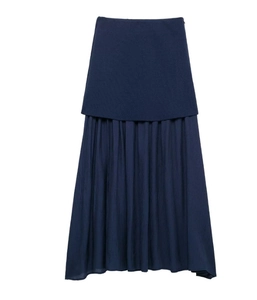 Détail de la jupe plissée bleu marine avec couture texturée et design épuré