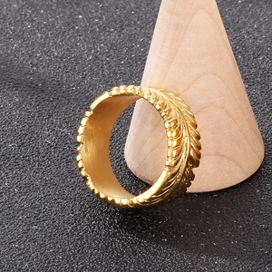 Macro detail of golden vintage feather texture on punk style men's titanium steel ring