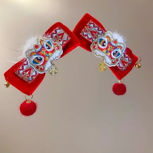 Close-up of Chinese New Year velvet hair clips with lion dance embroidery and bells
