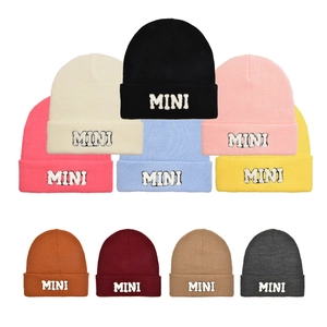 Vista piatta di berretti in maglia in vari colori con toppa MINI ricamata in dettaglio