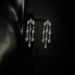 Close-up of silver tassel earrings featuring marquise and round cut cubic zirconia stones