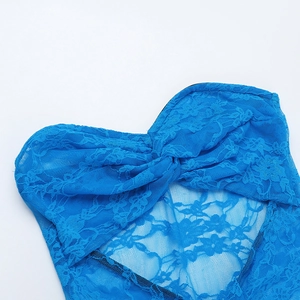Dettaglio dell'abito da spiaggia in pizzo blu acceso con nodo e trama floreale fine