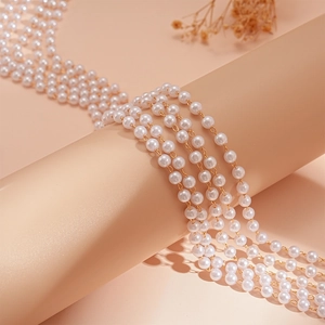 Elegant multi-layer faux pearl necklace with gold chain draped on a beige display stand