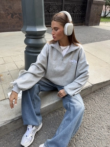 Loose half-zip grey sweatshirt with New York embroidery paired with wide-leg blue jeans