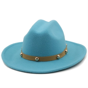 Detail of blue wool fedora hat featuring a brown band with gold metal studs