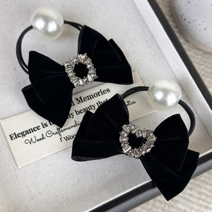 Detail of black velvet bow hair ties with sparkling rhinestones and elegant pearls
