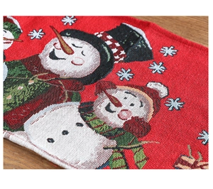 Macro detail of red Christmas table runner with snowman and snowflake jacquard texture
