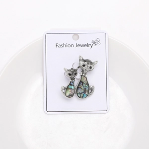 Detailed macro view of cat-shaped brooches with colorful abalone shell inlays in silver tone