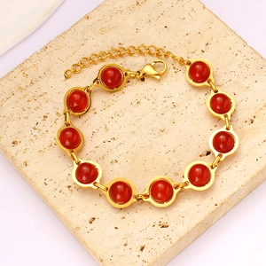 Detail of gold bead bracelet with ten red round gemstones and lobster clasp closure