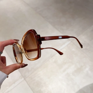 Detail of amber tortoiseshell sunglasses with gradient lenses and translucent resin frame