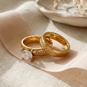 Detailed view of gold stainless steel bridal ring set with sparkling zircon on pink ribbon