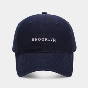 Close-up of white Brooklyn embroidery on navy cotton canvas baseball cap detail