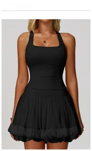 Detail of premium black racerback sports top paired with pleated trim skirt on model