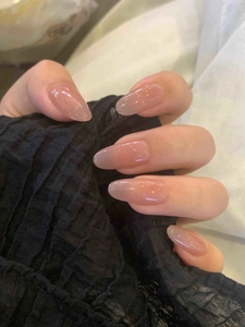 Nahaufnahme von langen ovalen Kunstnägeln in transparentem Nude-Rosa mit Glanz