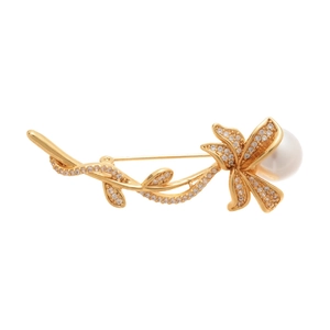 Elegant gold flower brooch with zircon leaves and a round pearl on a white background