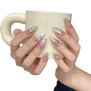 Pink cat eye press-on nails with silver glitter, white butterfly, and pearl accents