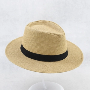 Close-up of tightly woven khaki straw hat featuring a classic black grosgrain ribbon band