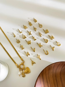 Detail of golden snake chain with heart charm, pearl, and full set of A-Z alphabet pendants