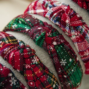 Close-up of knotted Christmas headbands with red green plaid and snowflake knit texture