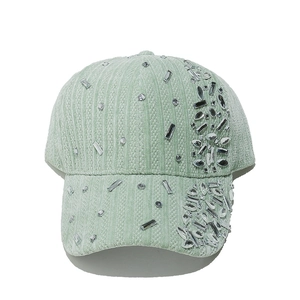 Detail of mint green corduroy baseball cap with sparkling multi-shaped rhinestones