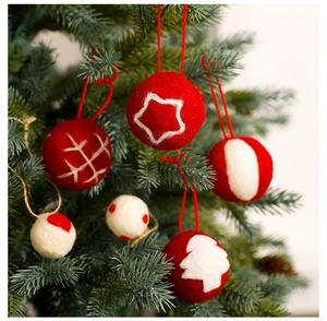 Close-up of red and white wool felt Christmas balls with star and snowflake patterns