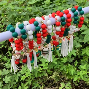 Christmas silicone beaded wristlet keychain with Santa tassels on a green background